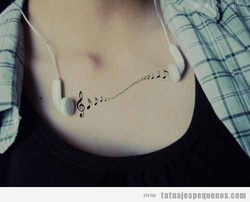 Tatuaje de notas musicales en el pecho de una chica