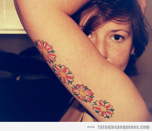 Tatuaje pequeño de flores en la parte interior del brazo