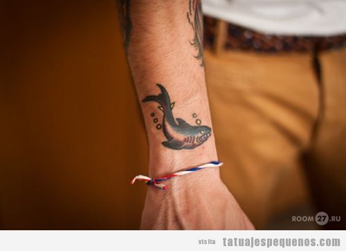Tattoo pequeño de un tiburón en el brazo de un chico