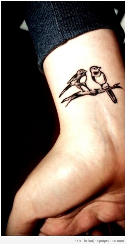 Tatuajes pequeños, pájaros realistas en una rama, en la muñeca