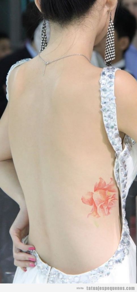Tatuaje pequeño rosa realista costado espalda