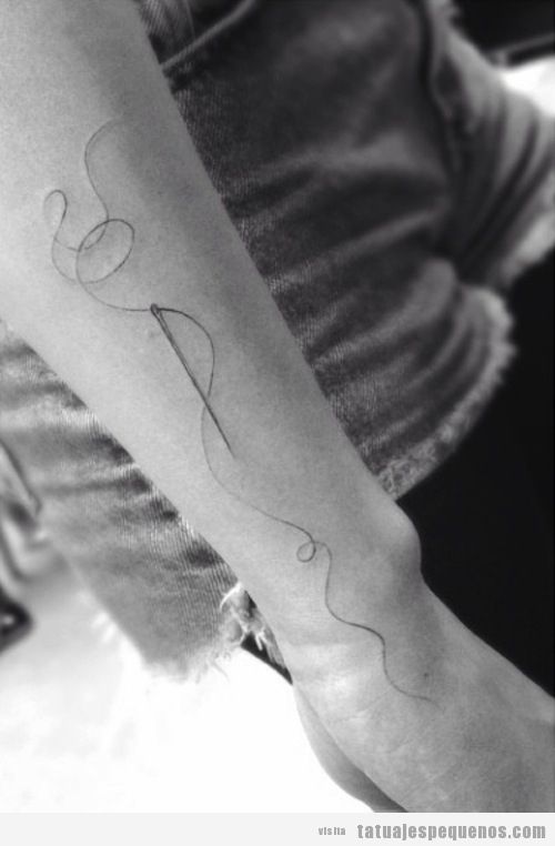 Tatuaje pequeño de un hilo y una aguja en el brazo