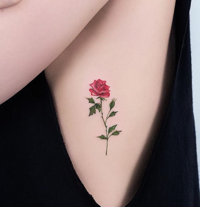 Tatuaje pequeño rosa en el costado