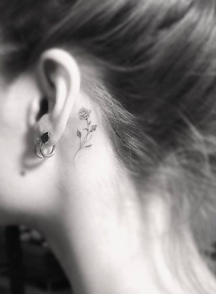 Tatuaje pequeño rosa detrás oreja