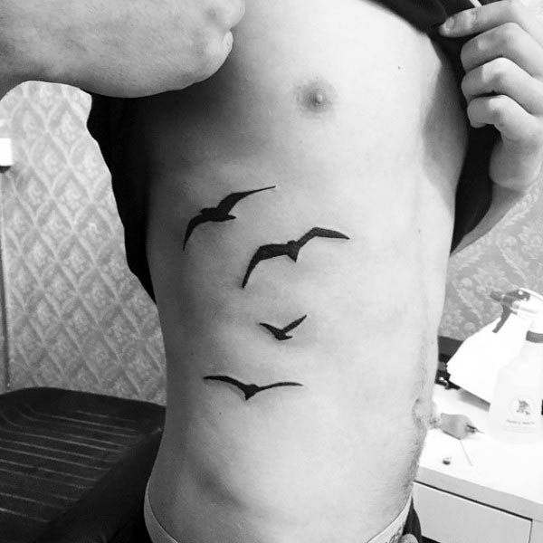 Tatuaje pequeño hombre costillas pájaros