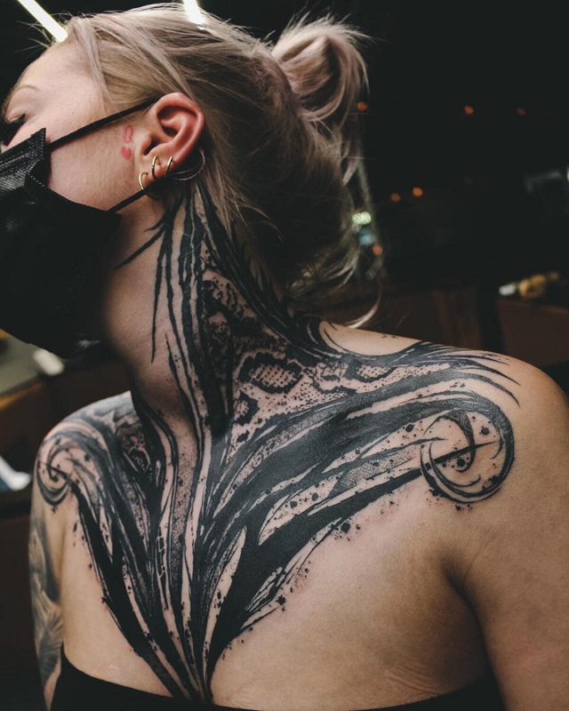 Tatuaje abastracto pecho y cuello chica